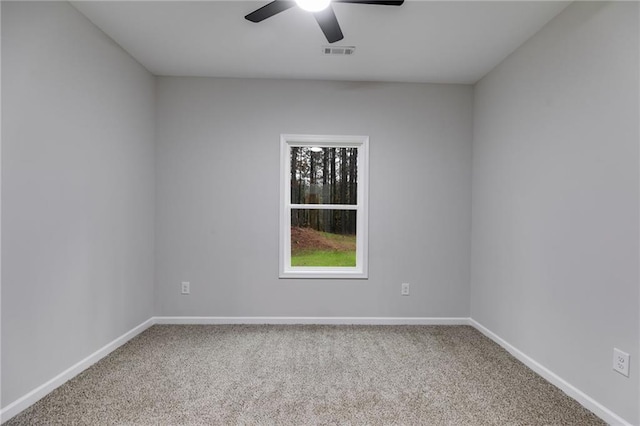 unfurnished room featuring carpet floors, visible vents, baseboards, and a ceiling fan