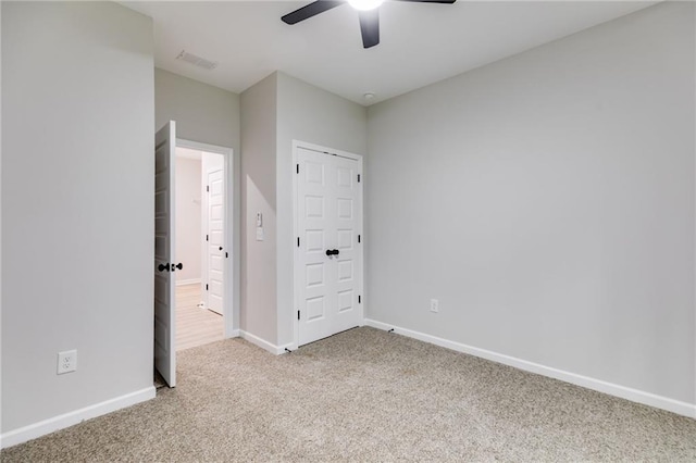 unfurnished bedroom with carpet floors, visible vents, baseboards, and ceiling fan