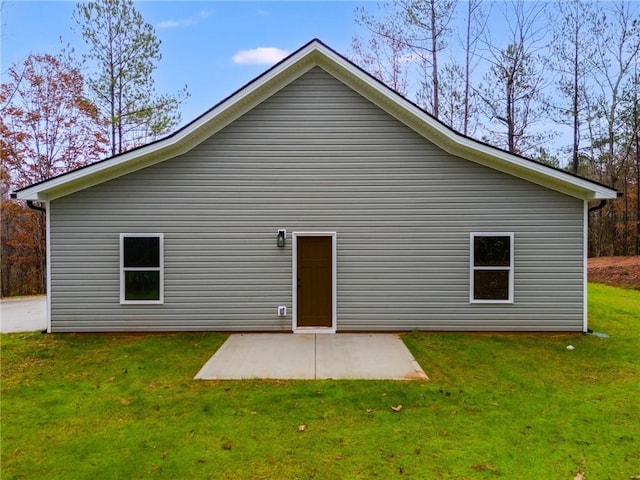 back of house with a patio area and a lawn