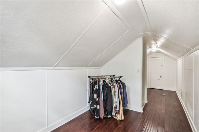 bonus room featuring hardwood / wood-style floors, vaulted ceiling, baseboards, and a textured ceiling