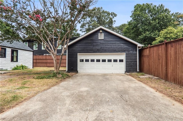 view of front of property featuring an outbuilding, fence, a garage, and a front yard