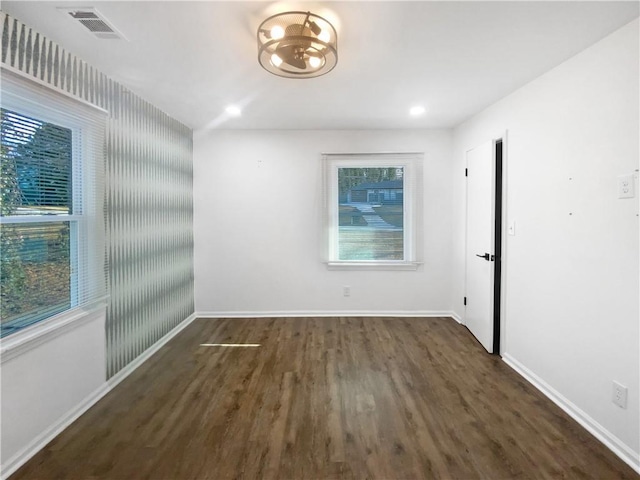 empty room with dark wood-type flooring and plenty of natural light