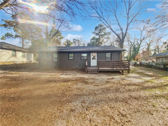 view of front facade featuring a wooden deck and a front yard