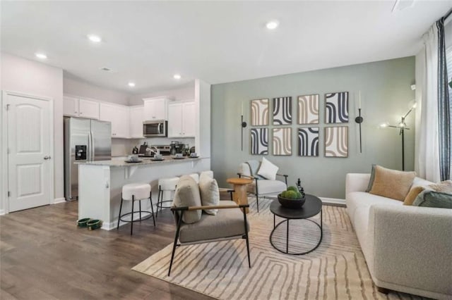 living room featuring baseboards, wood finished floors, and recessed lighting