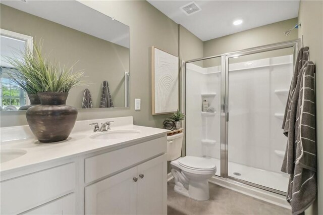 full bathroom featuring a stall shower, visible vents, a sink, and double vanity