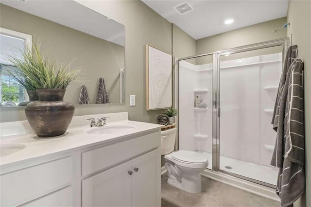 bathroom featuring visible vents, a sink, a shower stall, and double vanity