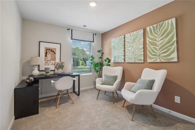 office area featuring baseboards, visible vents, and light colored carpet