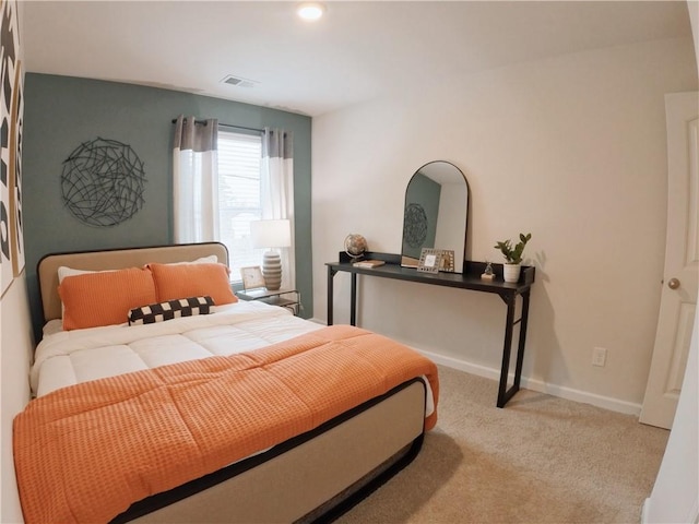 bedroom with light carpet, visible vents, and baseboards