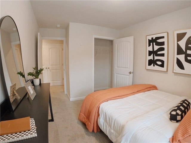 bedroom featuring a closet, light colored carpet, and baseboards