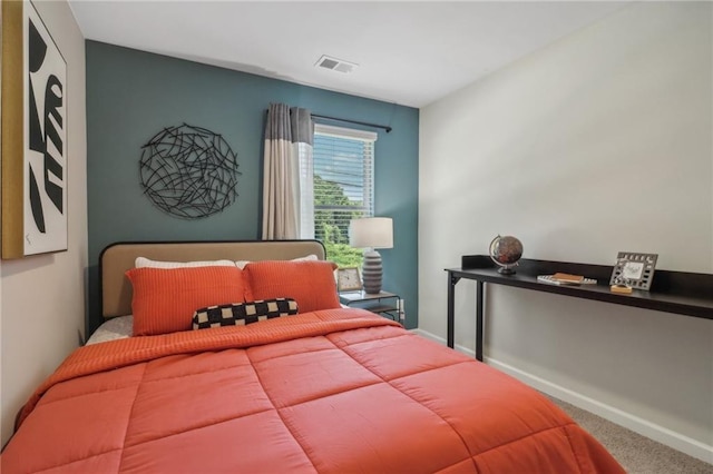 carpeted bedroom featuring baseboards and visible vents