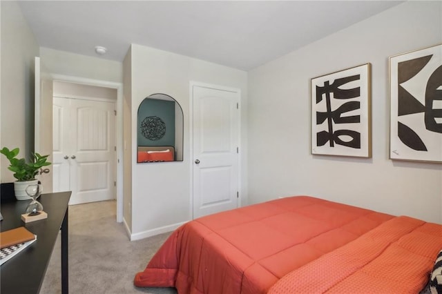 bedroom featuring light colored carpet and baseboards