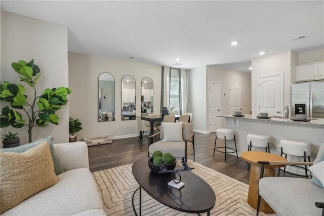 living area with visible vents, baseboards, dark wood finished floors, and recessed lighting