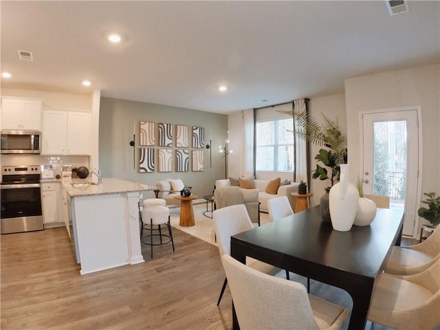 dining room featuring light wood-style floors, visible vents, and recessed lighting