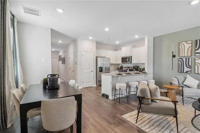 dining space featuring wood finished floors, visible vents, and recessed lighting