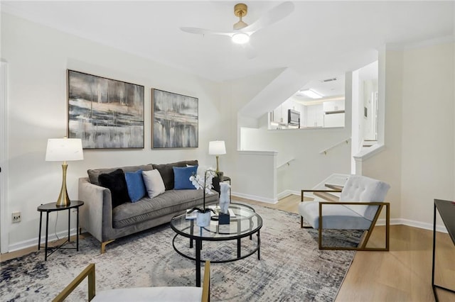 living room with light hardwood / wood-style floors and ceiling fan