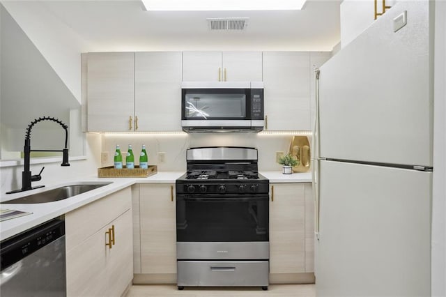 kitchen featuring sink, dishwasher, range with gas cooktop, and white refrigerator