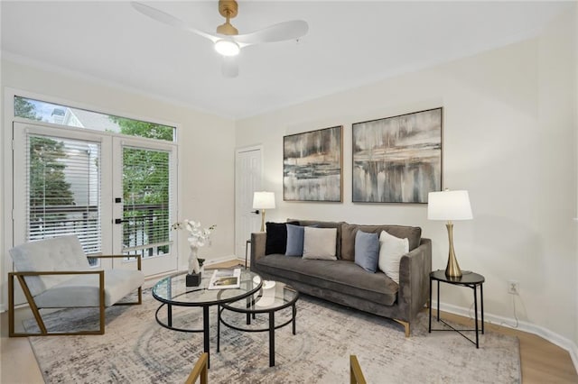 living room featuring light hardwood / wood-style floors, ceiling fan, french doors, and crown molding