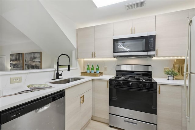 kitchen with sink, dishwasher, white refrigerator, and gas stove