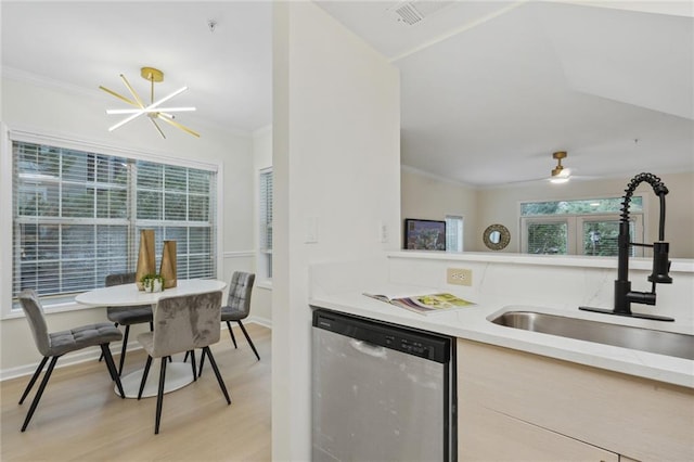 kitchen with stainless steel dishwasher, ceiling fan with notable chandelier, crown molding, light wood-type flooring, and sink