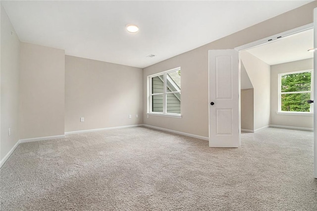 carpeted empty room featuring baseboards