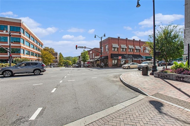 view of street with sidewalks, traffic lights, street lighting, and curbs