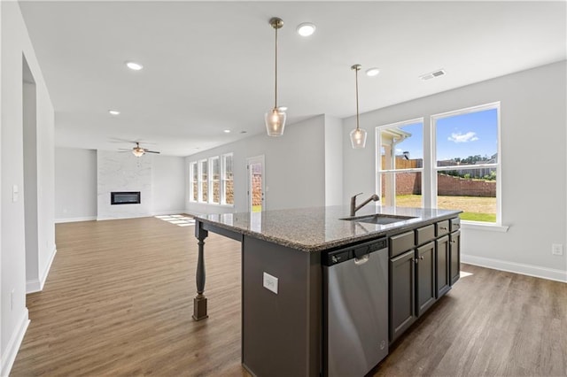 46 Cooper Dr, Mansfield, GA 30055 - kitchen featuring stainless steel dishwasher, ceiling fan, dark wood-style floors, stone countertops, and a center island with sink