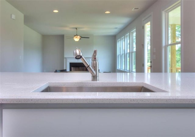 46 Cooper Dr, Mansfield, GA 30055 - kitchen view of recessed lighting, light stone countertops, and a ceiling fan