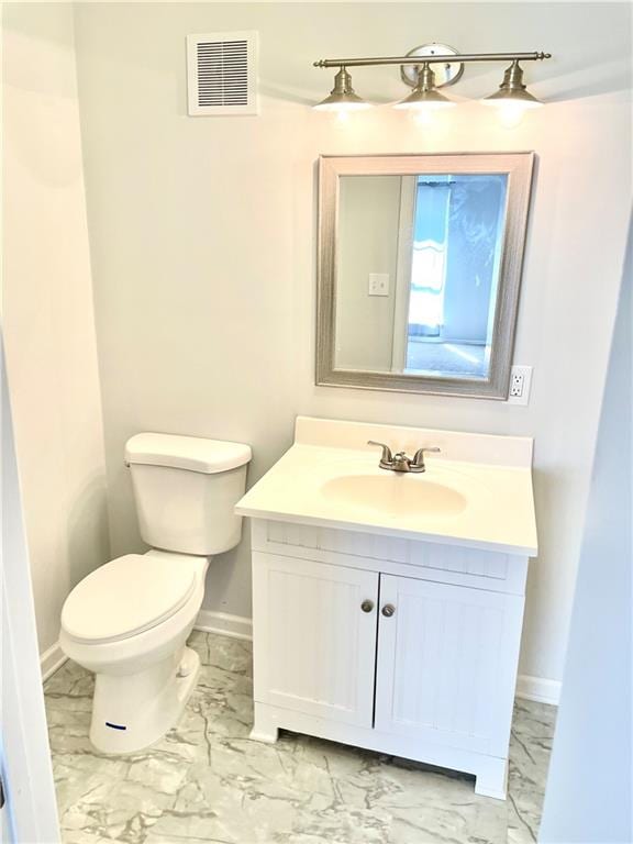 bathroom featuring tile patterned flooring, toilet, and vanity