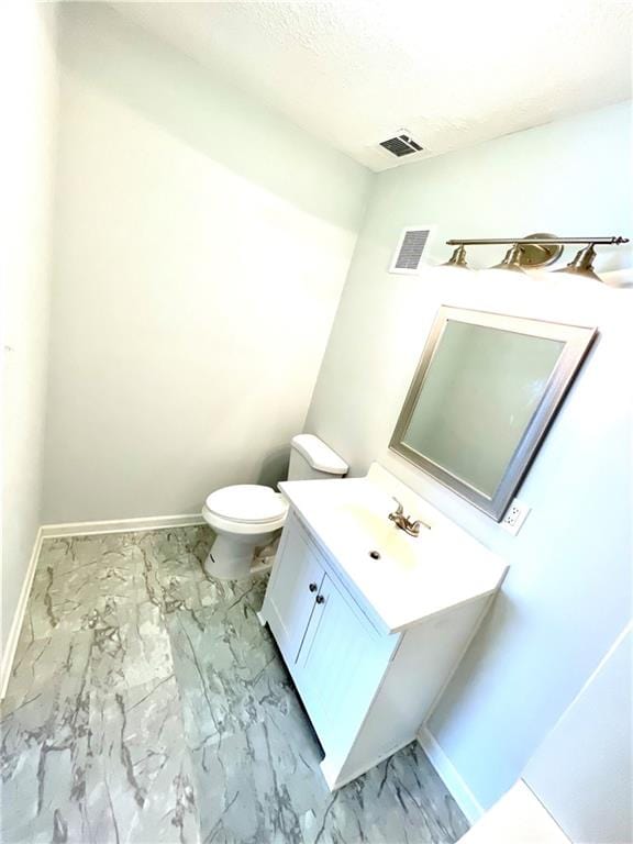 bathroom featuring vanity, tile patterned flooring, and toilet