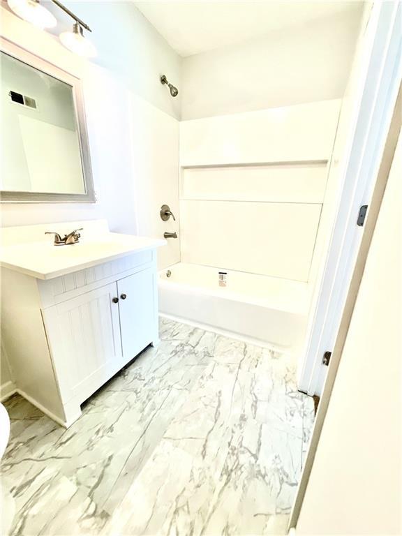 bathroom featuring tile patterned floors, shower / bathtub combination, and vanity