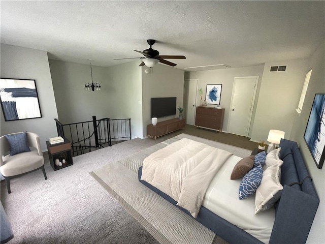 carpeted bedroom with a textured ceiling and ceiling fan with notable chandelier