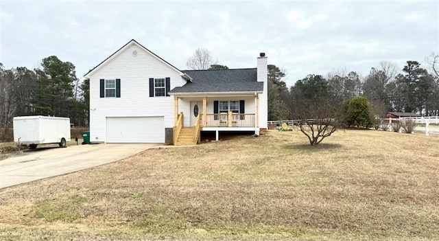 split level home featuring a porch, concrete driveway, a front yard, a chimney, and a garage