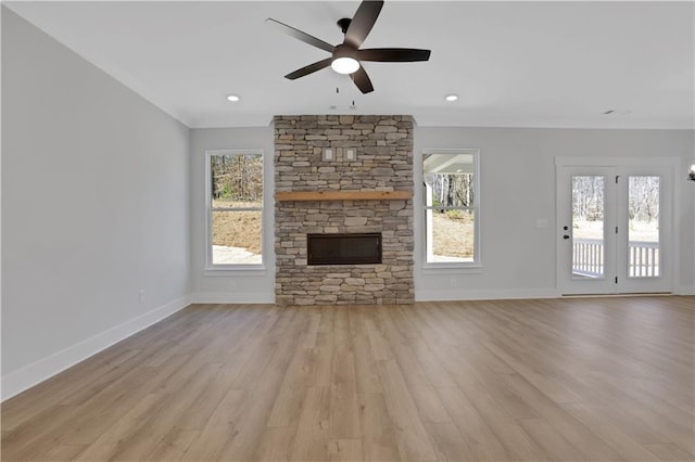 unfurnished living room featuring light wood finished floors, a fireplace, a ceiling fan, and baseboards