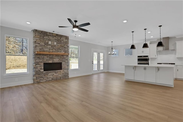 unfurnished living room with baseboards, light wood finished floors, a ceiling fan, and recessed lighting