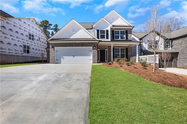 view of front of property featuring an attached garage, covered porch, brick siding, driveway, and a front yard