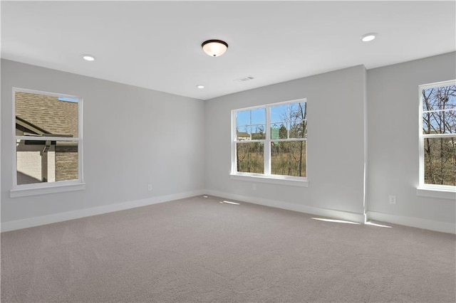 spare room featuring carpet floors, recessed lighting, visible vents, and baseboards