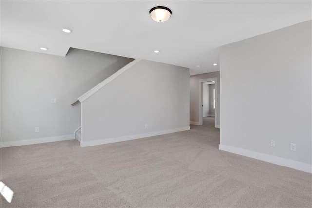 unfurnished living room featuring recessed lighting, light carpet, baseboards, and stairs