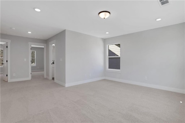 spare room featuring light carpet, baseboards, visible vents, and recessed lighting