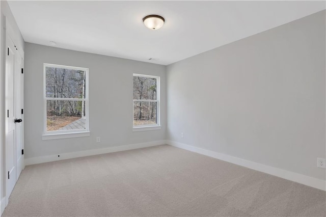 unfurnished room with light carpet and baseboards