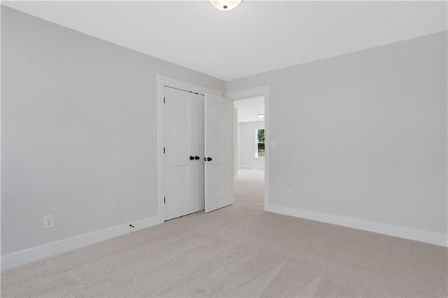 empty room with light carpet and baseboards