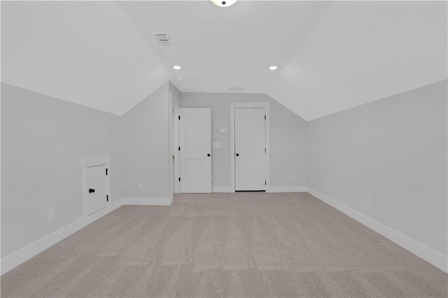 additional living space featuring visible vents, baseboards, light colored carpet, vaulted ceiling, and recessed lighting