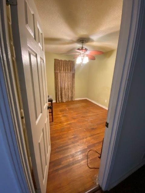 hall with hardwood / wood-style floors and a textured ceiling