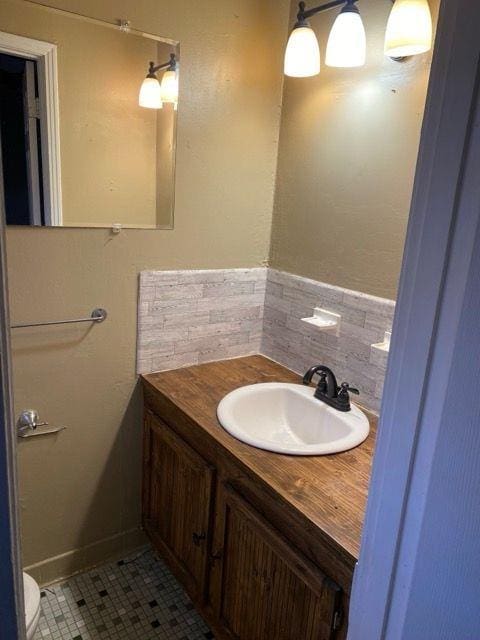 bathroom featuring toilet, vanity, tasteful backsplash, and tile patterned flooring