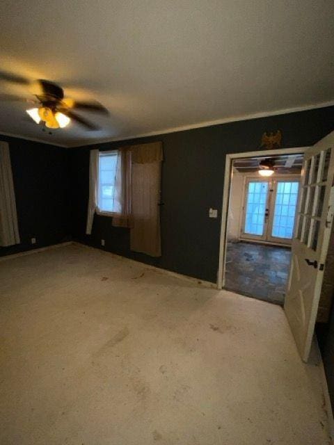 carpeted spare room with ceiling fan and french doors