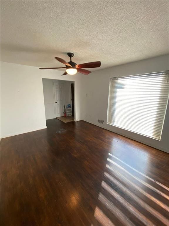 unfurnished room featuring ceiling fan, a textured ceiling, and dark hardwood / wood-style floors