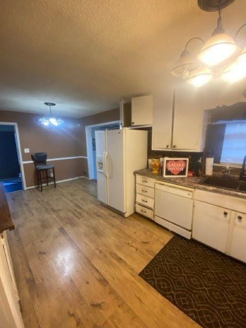 kitchen featuring sink, white appliances, white cabinetry, light wood-type flooring, and a textured ceiling