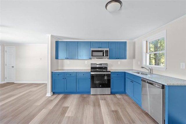 610 Ash Ln, Monroe, GA 30655 - kitchen featuring a sink, light wood-type flooring, crown molding, blue cabinetry, and appliances with stainless steel finishes