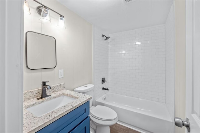 full bathroom with vanity, toilet, hardwood / wood-style flooring, and tiled shower / bath