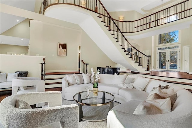 sunken living room featuring a high ceiling, stairway, wood finished floors, and recessed lighting