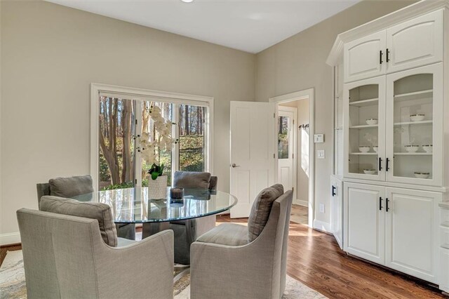 dining area with dark wood-type flooring and baseboards